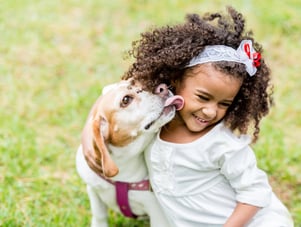 Happy girl with a dog licking her face