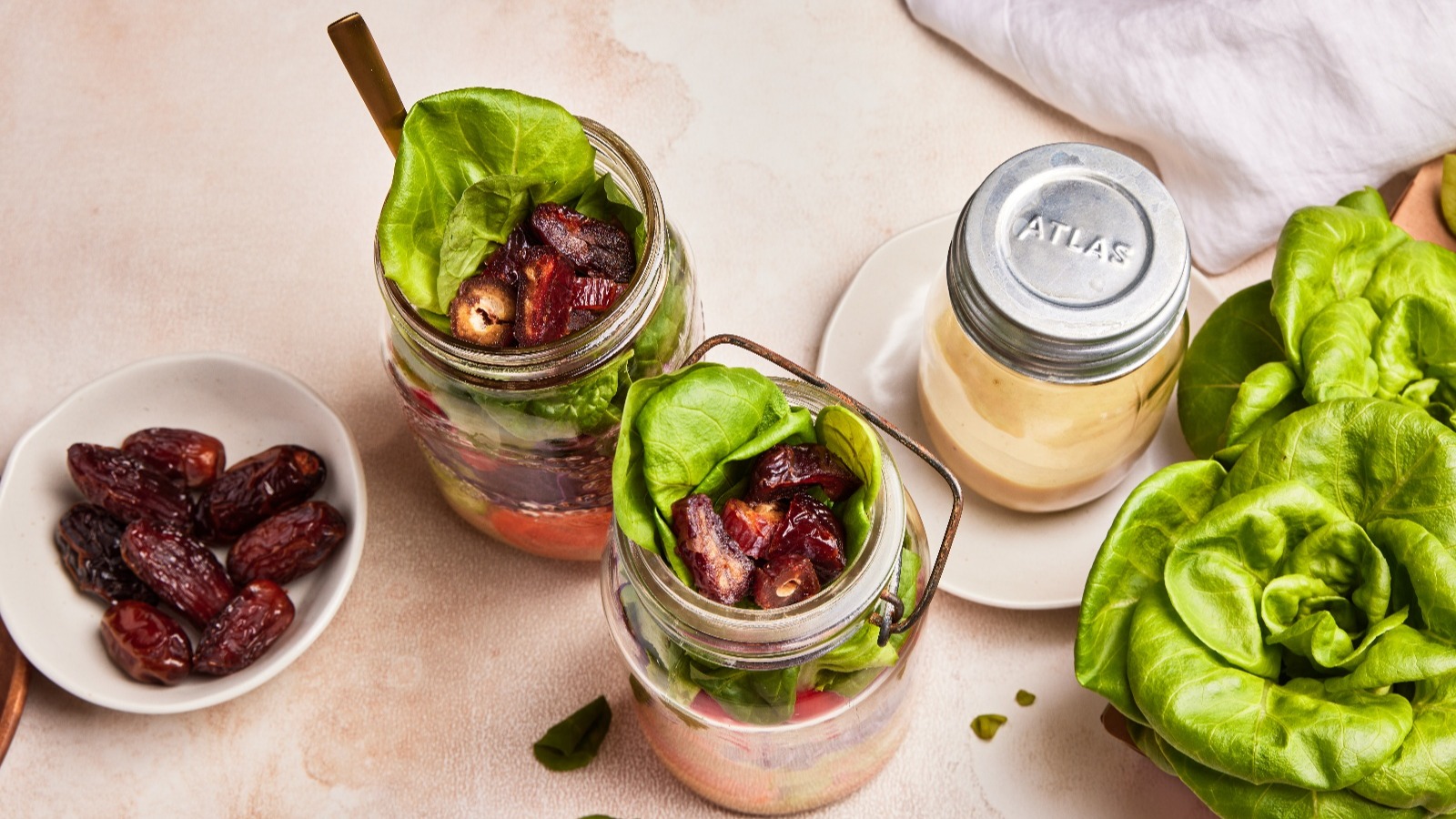 Individual green salad jars topped with fresh medjool dates